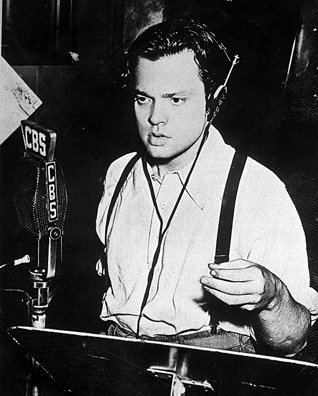 O cineasta norte-americano Orson Welles nos estdios da rdio CBS, em 1938, lendo um trecho do romance "A Guerra dos Mundos", de H.G. Wells