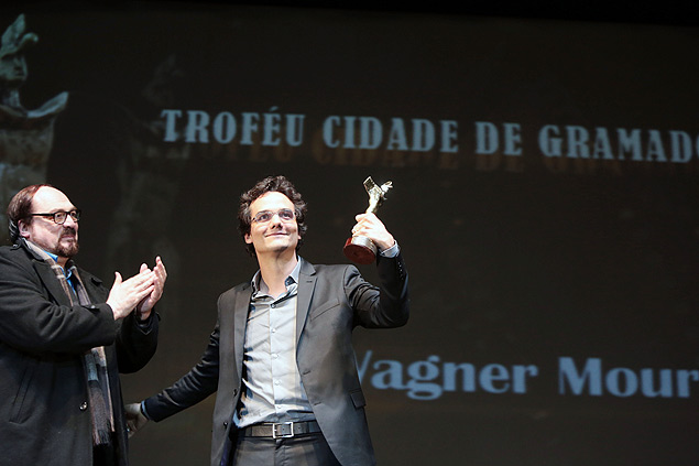O ator Wagner Moura recebe o trofu Cidade de Gramado das mos do curador Rubens Ewald Filho