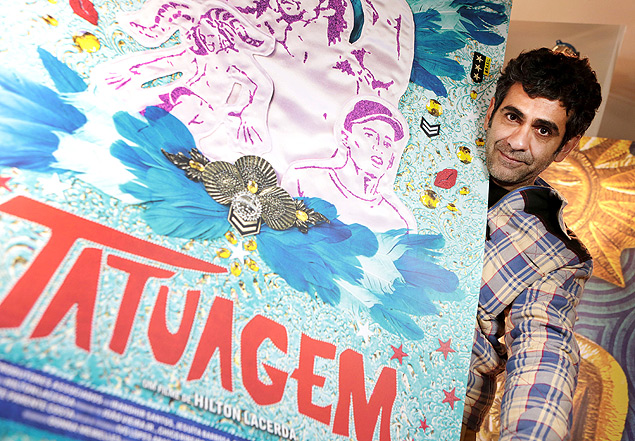 O diretor e roteirista Hilton Lacerda ao lado do cartaz de seu filme "Tatuagem", exibido no Festival de Gramado 2013