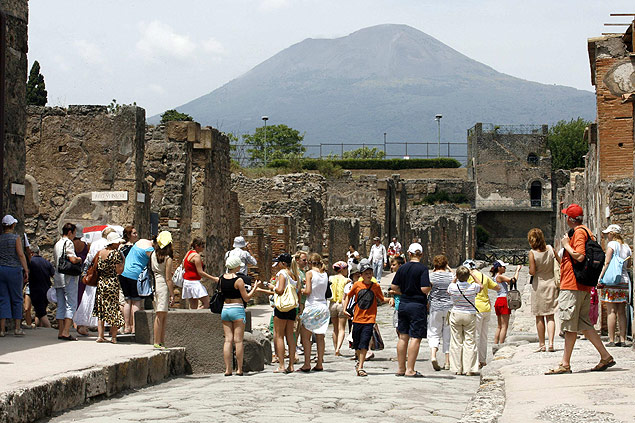 Grupos de turistas caminham pelas runas de Pompeia, cidade italiana destruda pela erupo do vulco Vesvio