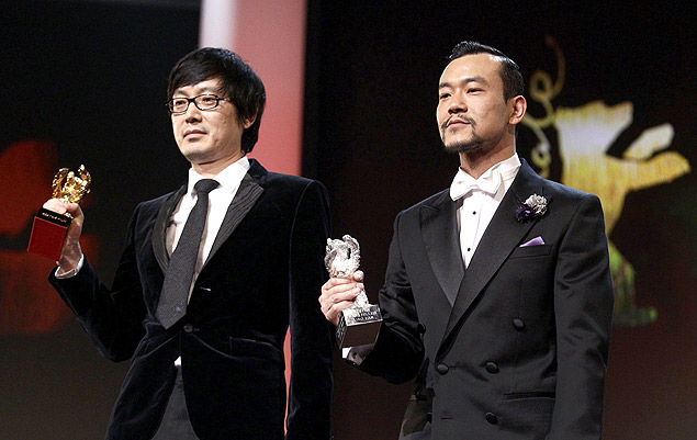 O diretor Diao Yinan e o ator Liao Fan, do filme 'Black Coal, Thin Ice', com seus prmios de Berlim