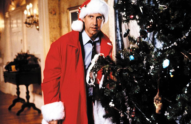 Chavy Chase (como Clark) encosta na rvore de Natal para tentar identificar o rudo que vem de l, em cena de 'Frias Frustradas de Natal' (1989)