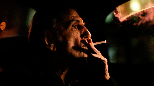O ator norte-americano Harry Dean Stanton fuma no carro, em cena do filme 