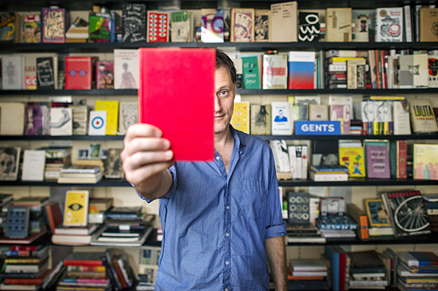 O designer Peter Mendelsund, em sua casa em Nova York, entre livros desenhados por ele
