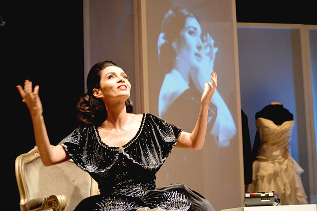 Claudia Ohana como Maria Callas, com imagem da cantora lrica ao fundo, em tela