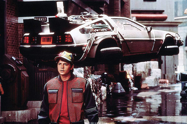 O ator Michael J. Fox [J.Fox] com um modelo estilizado do carro De Lorean [De.Lorean] em cena do filme 