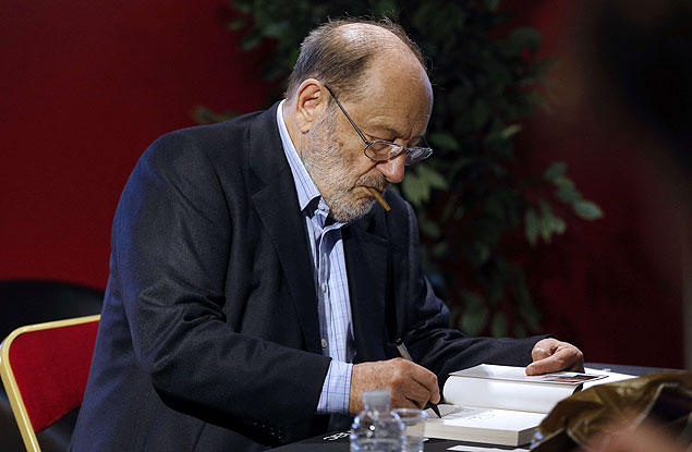 O autor italiano Umberto Eco autografa exemplar de seu novo livro 
