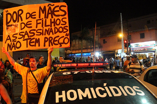 Manifestante protesta contra ao policial no Rio que causou a morte de Eduardo Felipe Santos Victor; policiais fraudaram a cena do crime 