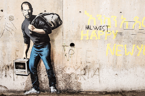 This picture taken on December 12, 2015 shows a street art graffiti representing Steve Jobs, founder and late CEO of Apple, by elusive British artist Banksy at the migrant camp known as the 