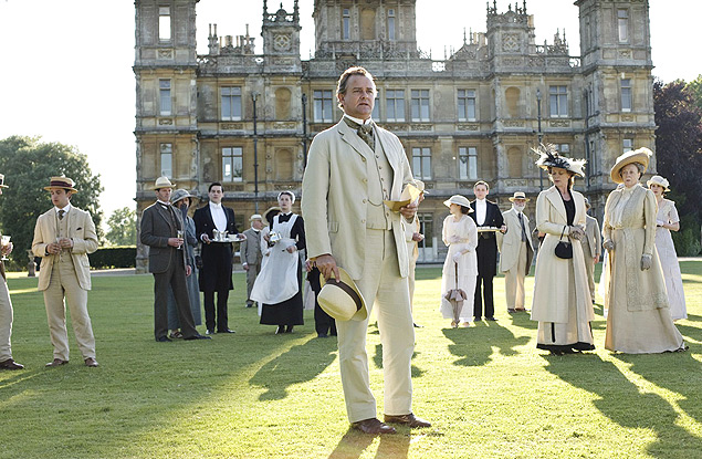 O ator Hugh Bonneville  frente do restante do elenco de 'Downton Abbey' no gramada da manso Highclere Castle