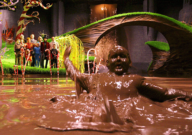 ORG XMIT: 400701_0.tif O ator Philip Wiegratz em cena do filme "A Fantstica Fbrica de Chocolate", de Tim Burton. Actor Philip Wiegratz portrays the character "Augustus Gloop" as he falls into a chocolate river as others watch from shore in a scene from director Tim Burton's new fantasy adventure film "Charlie and The Chocolate Factory" in this undated publicity photograph. The film also stars Johnny Depp and opens in the United States July 15, 2005. NO SALES REUTERS/Peter Mountain/Warner Bros./Handout 