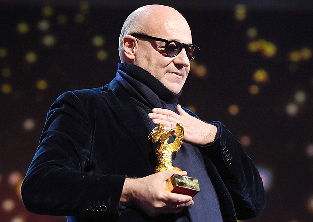 Italian director Gianfranco Rosi reacts after receiving the Golden Bear for Best Film for the film 