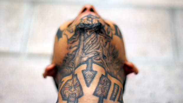 An imprisoned member of street gang Mara 18 poses for a photograph at the Izalco prison, about 65 km (40 miles) from San Salvador May 20, 2013. Inmates handed over handmade knives and more than 60 cell phones and other not-permitted articles in an effort to keep the truce between the country's two most powerful gangs Mara 18 and Mara Salvatrucha (MS-13), following a truce treaty signed by both sides in March 2012 to reduce violent crimes in the country. REUTERS/Ulises Rodriguez (EL SALVADOR - Tags: CIVIL UNREST CRIME LAW TPX IMAGES OF THE DAY) ORG XMIT: CDG06