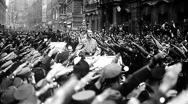 Multido sada o ditador nazista Adolf Hitler, que desfila em carro pelas ruas de Munique em 1933