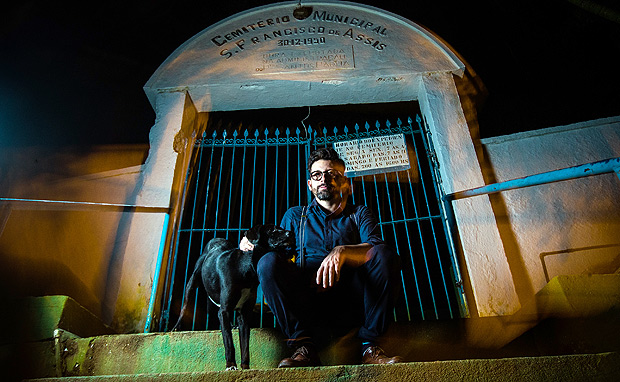 O escritor J.P. Cuenca na entrada do cemitério municipal São Francisco de Assis