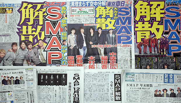This picture shows Japanese papers reporting on the popular Japanese boy band SMAP's break up at the end of the year in Tokyo on August 14, 2016. The five members of the group, now in their late 30s and early 40s, are regularly referred to as "national idols", and have dominated Japan's show business industry for the past quarter of a century. / AFP PHOTO / TORU YAMANAKA ORG XMIT: TY132