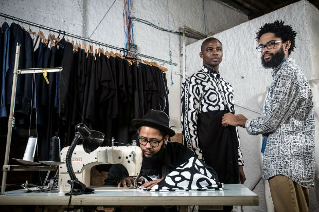 Os rappers Emicida (sentado) e Evandro Fiti ajustam roupas no ateli do estilista Joo Pimenta