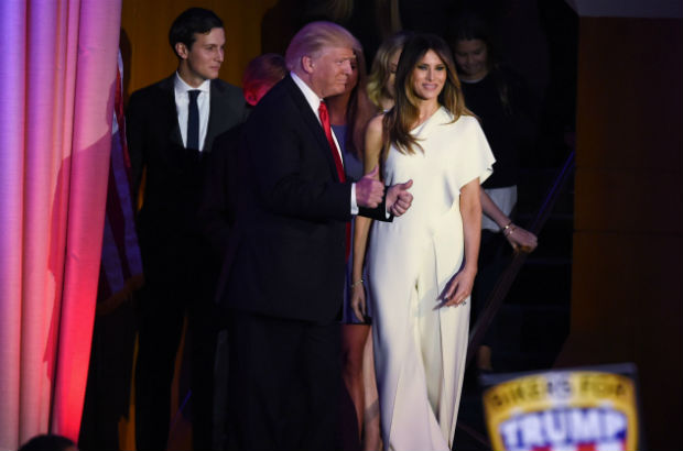 Republican presidential candidate Donald Trump, flanked by wife Melania, gives the thumbs-up as he arrives with members of his family for an election night party at the New York Hilton Midtown in New York on November 9, 2016. Trump won the US presidency. / AFP PHOTO / Timothy A. CLARY