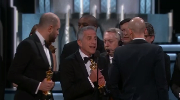 Um produtor do Oscar, com microfone na cabeça, entra no palco e avisa que houve um erro