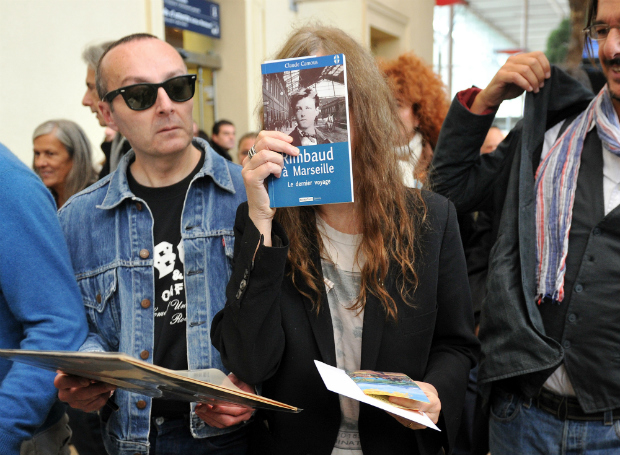 *** EM ALTA*** US rock singer and poet Patti Smith poses with the book "Rimbaud a Marseille, le dernier voyage" (Rimbaud in Marseille, The Last Travel) by Claude Camous, as she arrives at Saint-Charles railway station in Marseille, southeastern France, on November 07, 2011, where she pays tribute to French poet Arthur Rimbaud. Patti Smith also organised a photo exhibition at the Wadsworth Atheneum in Hartford, Connecticut, entitled "Patti Smith : Camera Solo", featuring 70 of black-and-white silver gelatin prints Smith shot with a vintage Polaroid as well as photographs of Rimbaud's ustensils (taken in a museum). AFP PHOTO/GERARD JULIEN / AFP PHOTO / GERARD JULIEN ORG XMIT: GJ1816 ***DIREITOS RESERVADOS. NO PUBLICAR SEM AUTORIZAO DO DETENTOR DOS DIREITOS AUTORAIS E DE IMAGEM***
