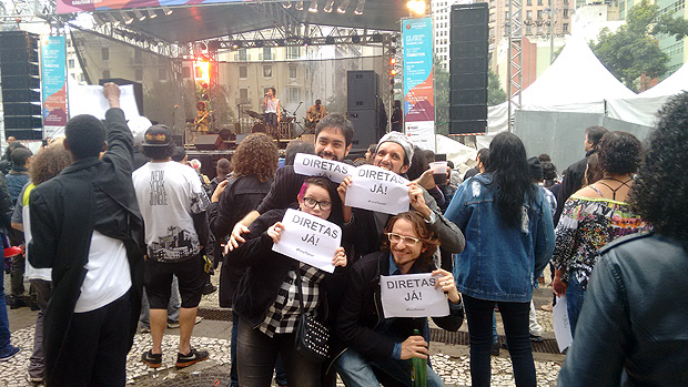 Fs seguram cartazes com "Diretas J!" em show de Filipe Catto, no palco Boulevard So Joo