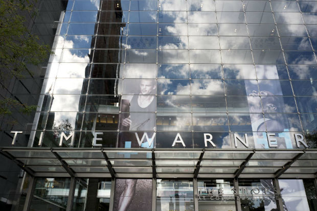 FILE - In this Monday, Oct. 24, 2016 file photo, clouds are reflected in the glass facade of the Time Warner building in New York. AT&T's plans to buy Time Warner for around $85 billion was one of the biggest business stories of 2016. (AP Photo/Mark Lennihan, File) ORG XMIT: PTM505