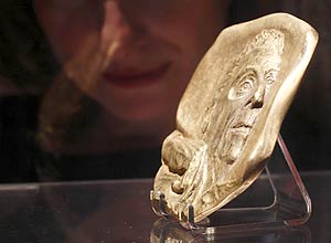 Mulher observa medalha de bronze com rosto de Lucian Freud