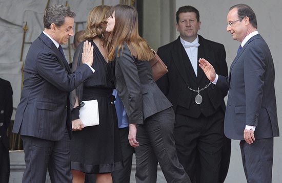 Sarkozy e Hollande se cumprimentam enquanto Velrie Trierweiler e Carla Bruni fazem o mesmo em cerimnia