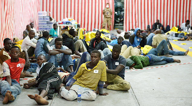 Parte dos imigrantes africanos que foram retirados do mar aguardam desembarque na ilha de Lampedusa