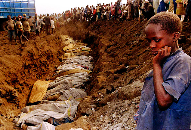 Menina olha para uma vala comum, onde dezenas de corpos foram colocados, vtimas genocdio por extremistas hutus, em Ruanda