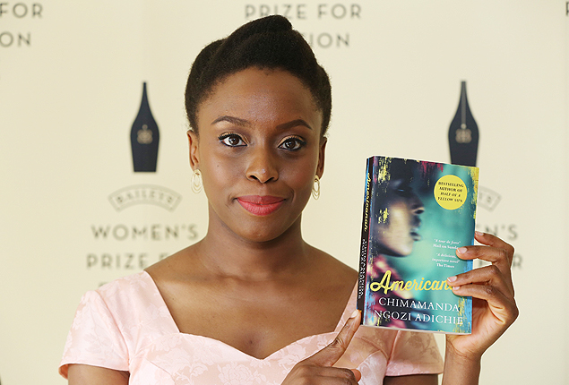 A escritora Chimamanda Ngozi Adichie com seu livro 