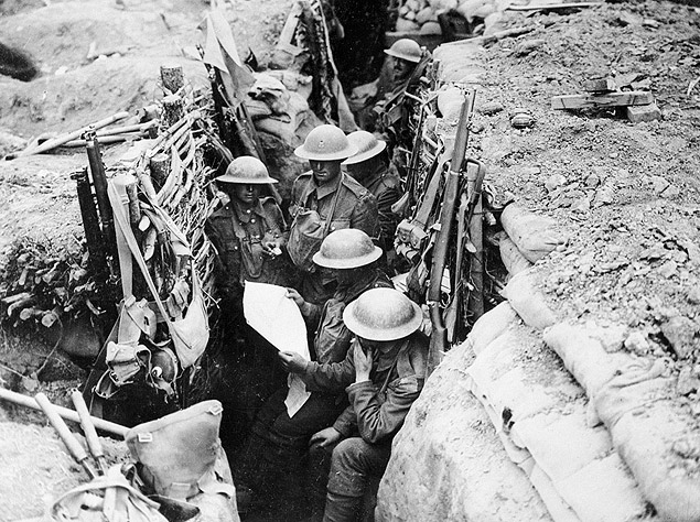 Soldados britnicos leem notcias do conflito em um das trincheiras da linha de frente durante a Primeira Guerra.