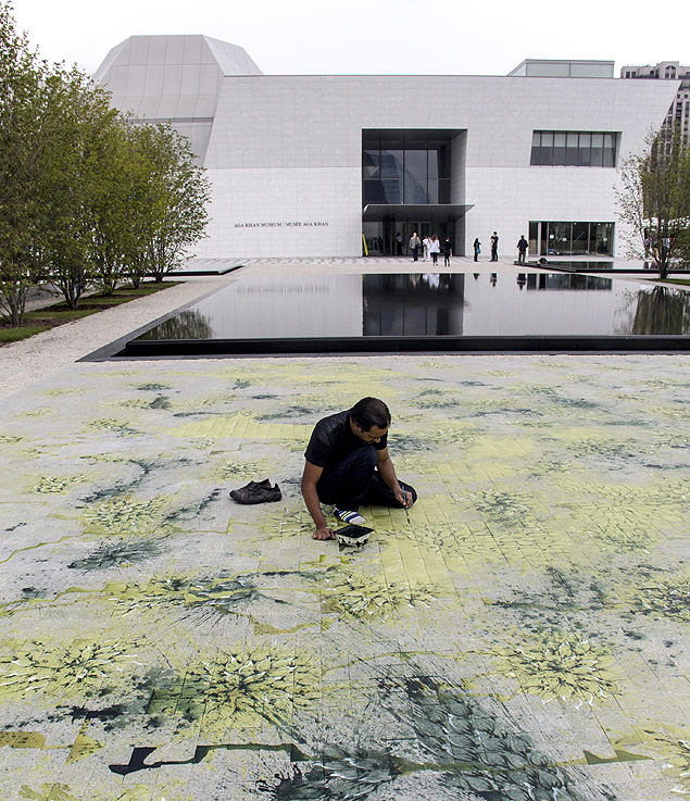 O artista paquistans Imran Qureshi terminando uma obra diante do Museu Aga Khan