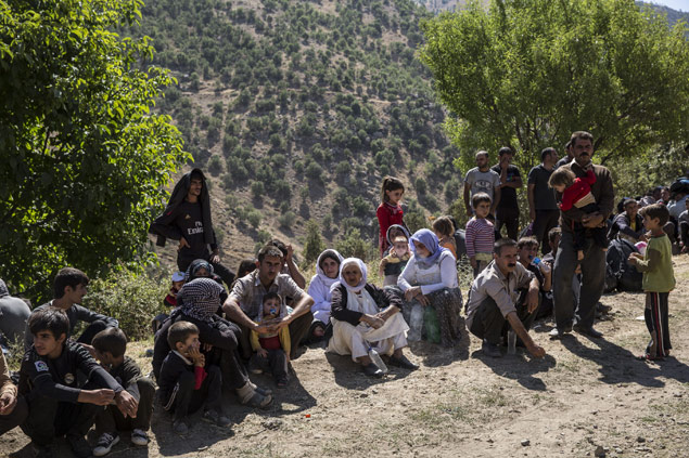 Um grupo da minoria yazidi descansa aps chegada no povoado de Roboski