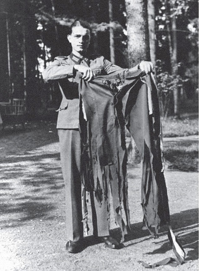 Soldado mostra o que sobrou das calas de um dos feridos no atentado contra Hitler em 20 de julho de 1944