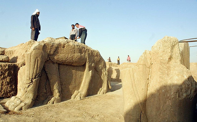 Trabalhadores iraquianos limpam est�tua de touro alado no s�tio arqueol�gico ass�rio de Nimrud, em 2001 