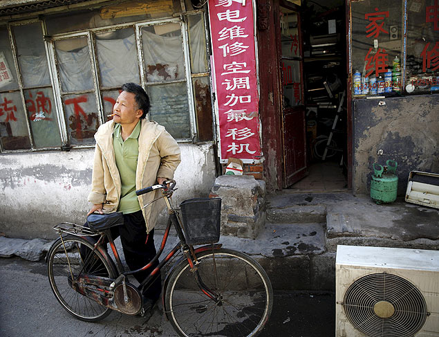 O chins Li Renjun com sua bicicleta em um hutong de Pequim
