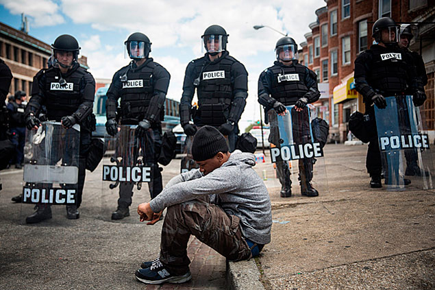 Daquan Green, 17, em frente de tropa que continha protesto após funeral de Freddie Gray, 25, morto pela polícia em Baltimore
