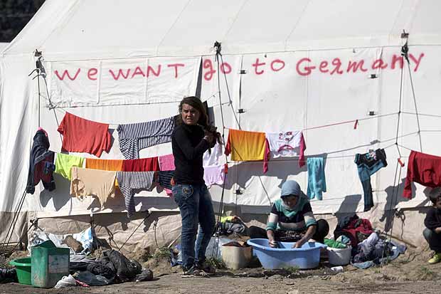 Imigrante lava roupas em acampamento na fronteira da Grécia com a Macedônia