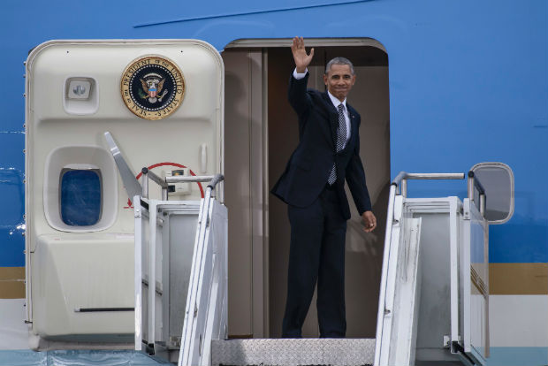 US President Barack Obama waves as he boards plane "Air Force One" prior to his departure on November 18, 2016 at the Tegel airport in Berlin, where the US President met the German Chancellor and other European leaders. US President Barack Obama's choice of Berlin as the stop for his European farewell tour has been interpreted by some observers as the passing of baton of the defence of liberal democracy to German Chancellor Angela Merkel. / AFP PHOTO / CLEMENS BILAN ORG XMIT: 036