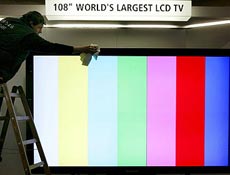 Homem limpa a maior TV de LCD do mundo nos preparativos para a Cebit, em Hanover