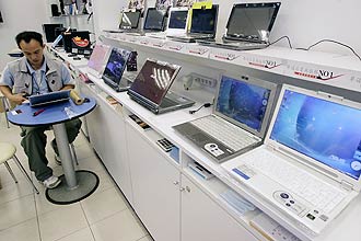 Atendente usa computador em loja de notebooks; governo estima valor unitário de laptop para auditores da CGU a R$ 6.777,46