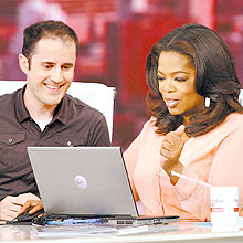 Evan Williams e a apresentadora Oprah Winfrey acessam o Twitter na TV norte-americana
