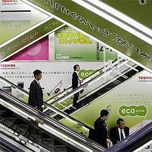Consumidores observam anncios da Toshiba em loja de eletrnicos no Japo; empresa interrompe fabricao de celulares