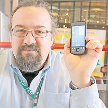 Chris DiBona, do Google, mostra seu celular com Android em feira de software livre