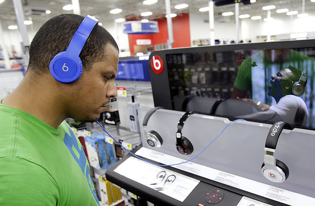 FILE - In this May 28, 2014 file photo, Eric Soriano listens to music with a pair of Beats headphones at a Best Buy store in Orlando, Fla. With paid subscriptions to music streaming services like Beats Music, Spotify, Pandora and others, you can listen to as many songs as you want on a variety of personal computers, phones, tablets and other devices. (AP Photo/John Raoux) ORG XMIT: NYBZ134