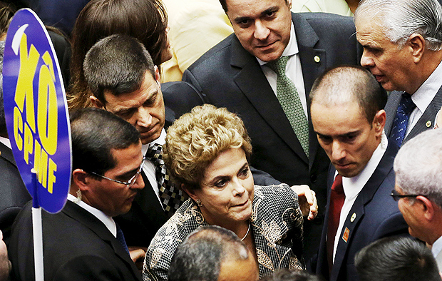 Dilma Rousseff walks past by sign that reads "No CPMF (a financial transactions tax", as she arrives to the session of Brazil's Congress 