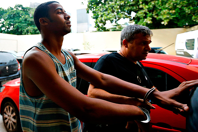 Rai de Souza (L), 22, suspected of being involved in the gang rape of a teenage girl, is escorted at the Police Station for crimes against minors in Rio 
