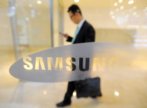 Homem caminha prximo ao logotipo da Samsung na sede da empresa, em Seul