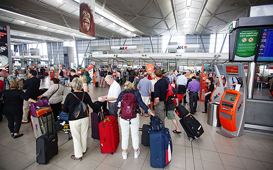Passageiros esperam em terminal de aeroporto de Sydney, tentando reagendar voos da Qantas